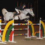 Eduardo Menezes and the grey mare Caruschka clear a rainbow-hued oxer.